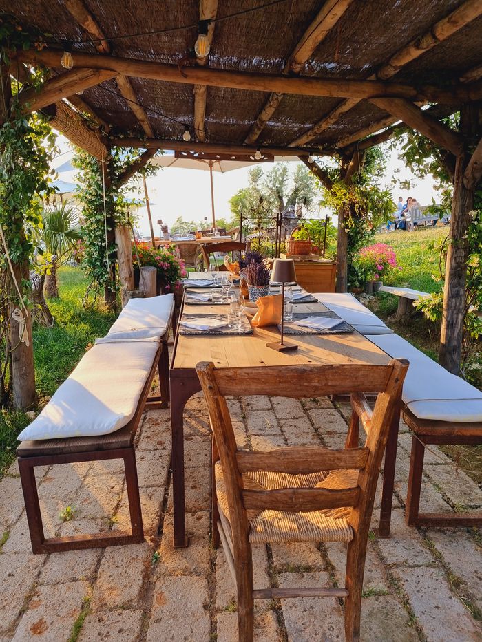 Tavolo lungo apparecchiato sotto la pergola de La Galeazza