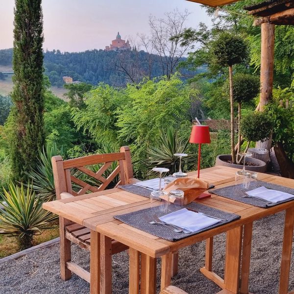 Tavolo in legno apparecchiato con vista sul Santuario di San Luca